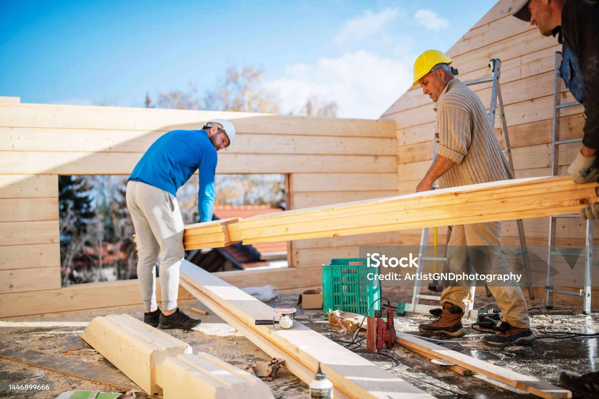 Team of construction workers building a wooden cabin.